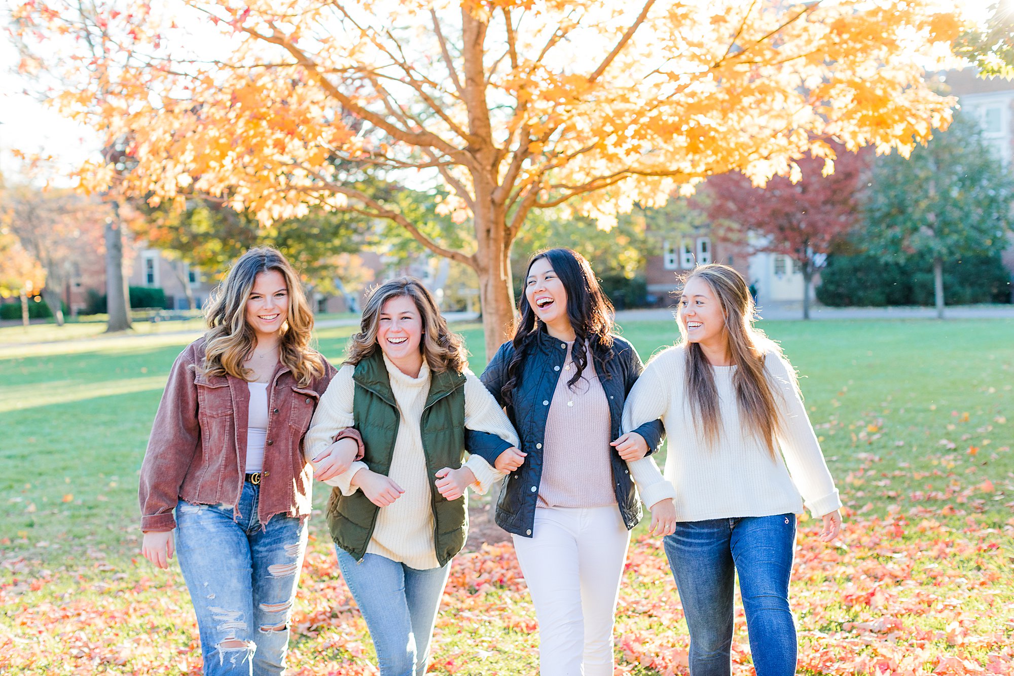 Girls walking towards camera laughing for fall senior portraits in Charlottesville, VA.