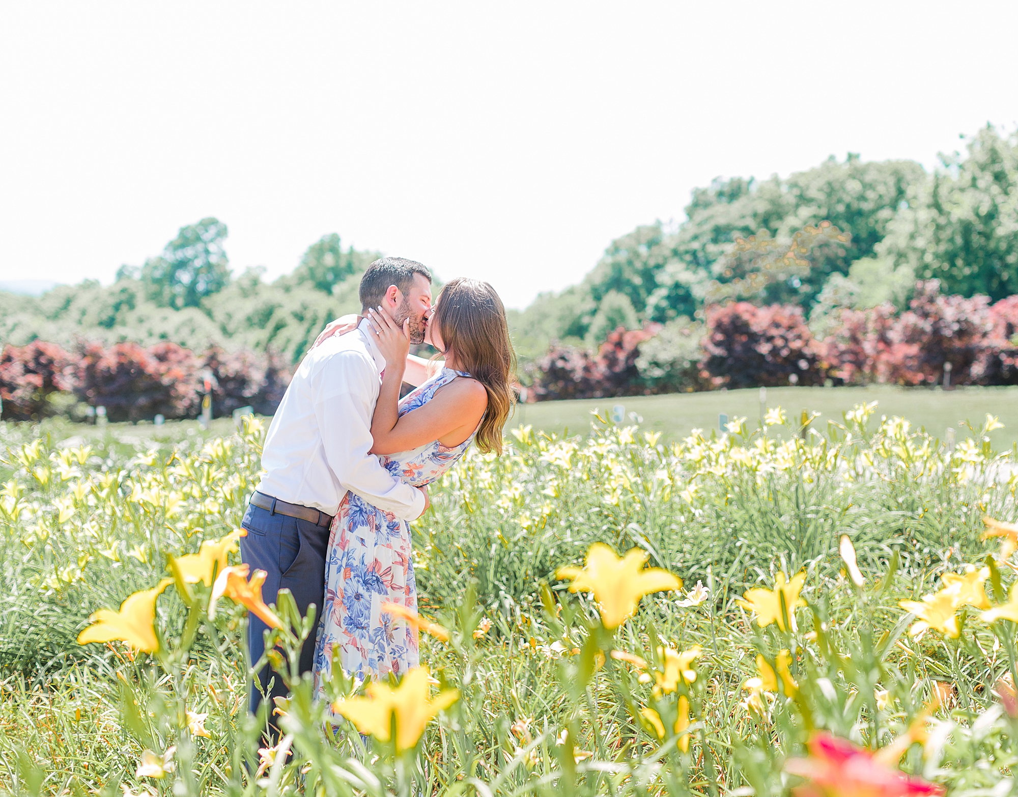 Couple kissing in field of tulips.