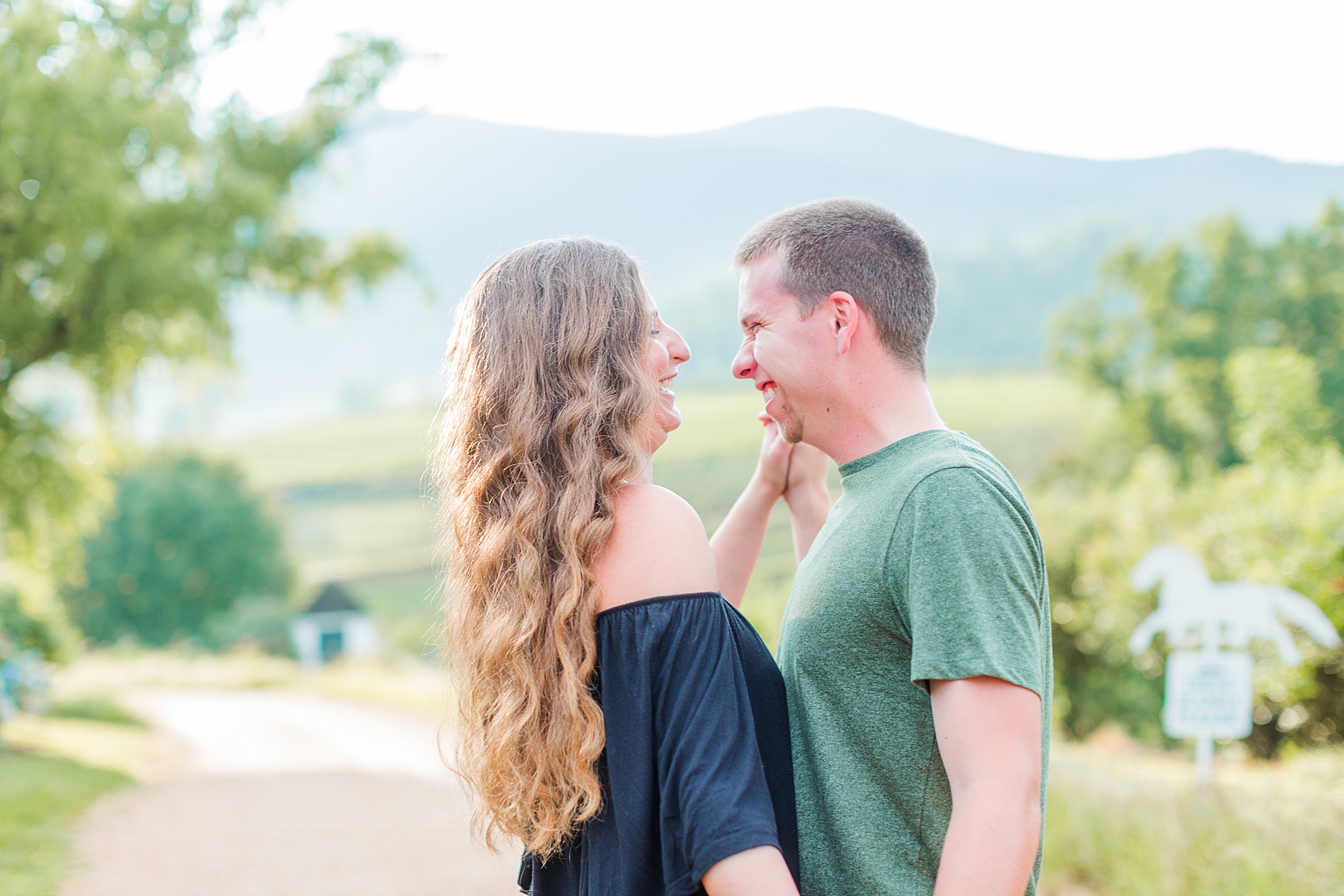 Newly engaged couple smiling at each other with scenic mountain views for their Virginia engagement session.