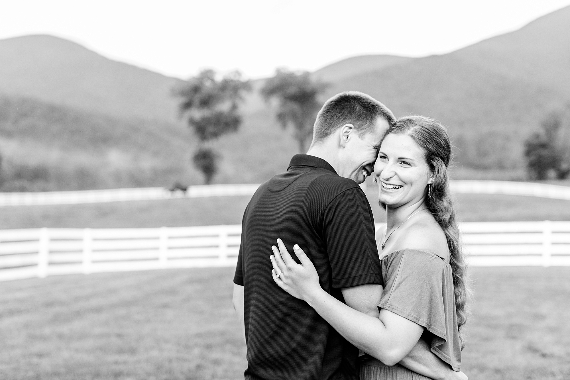 Newly engaged couple smiling at each other with scenic mountain views for their Virginia engagement session.