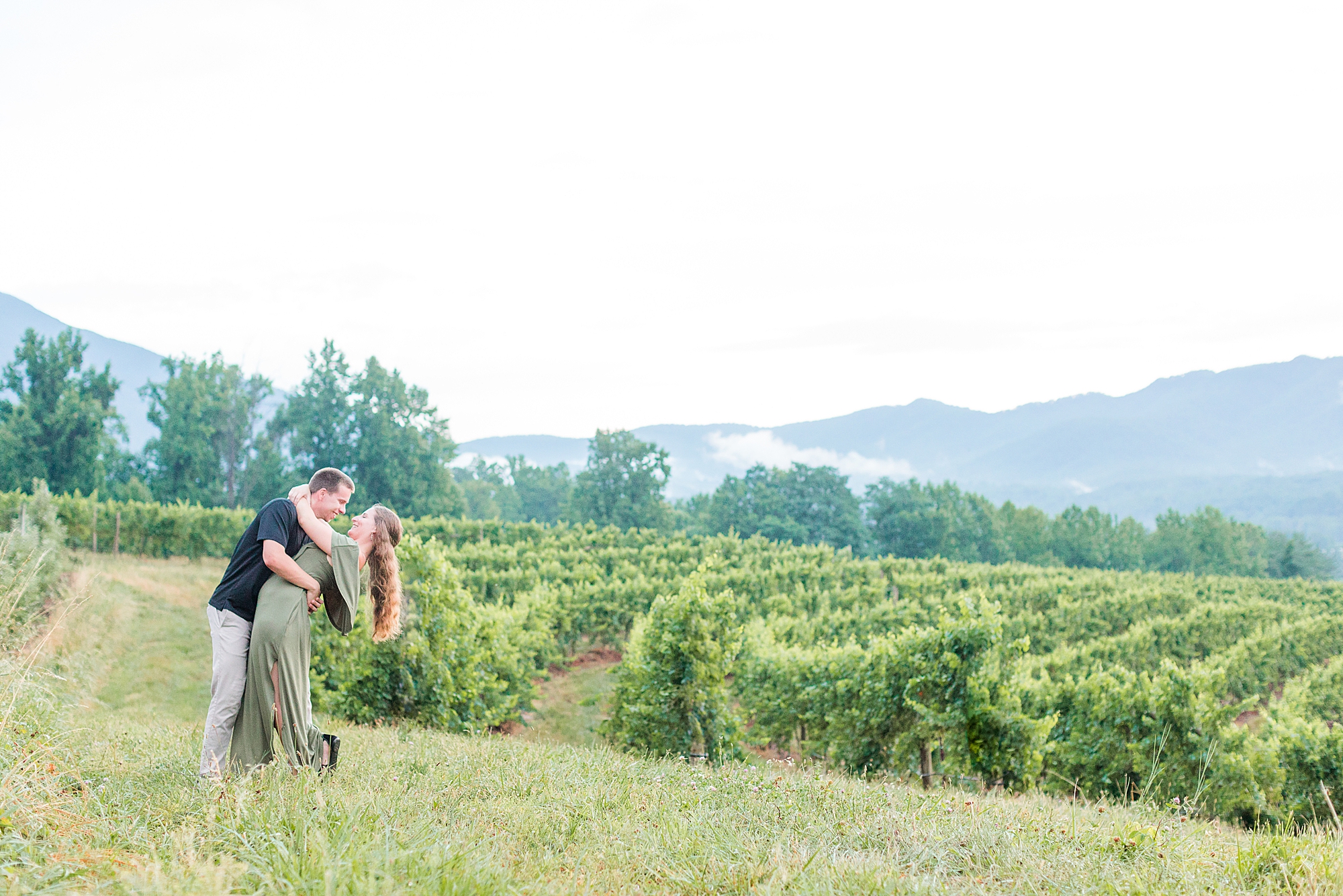 Virginia vineyard wedding venue with couple kissing in background.