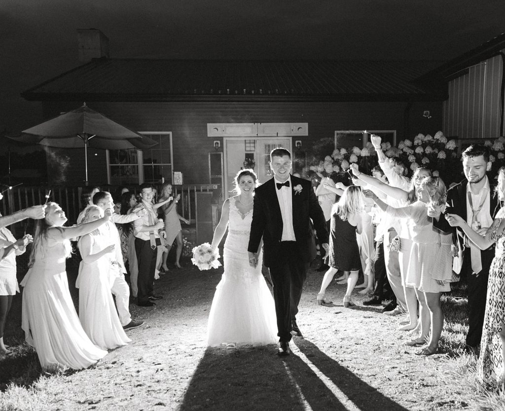 Bride and groom exit wedding with sparklers.