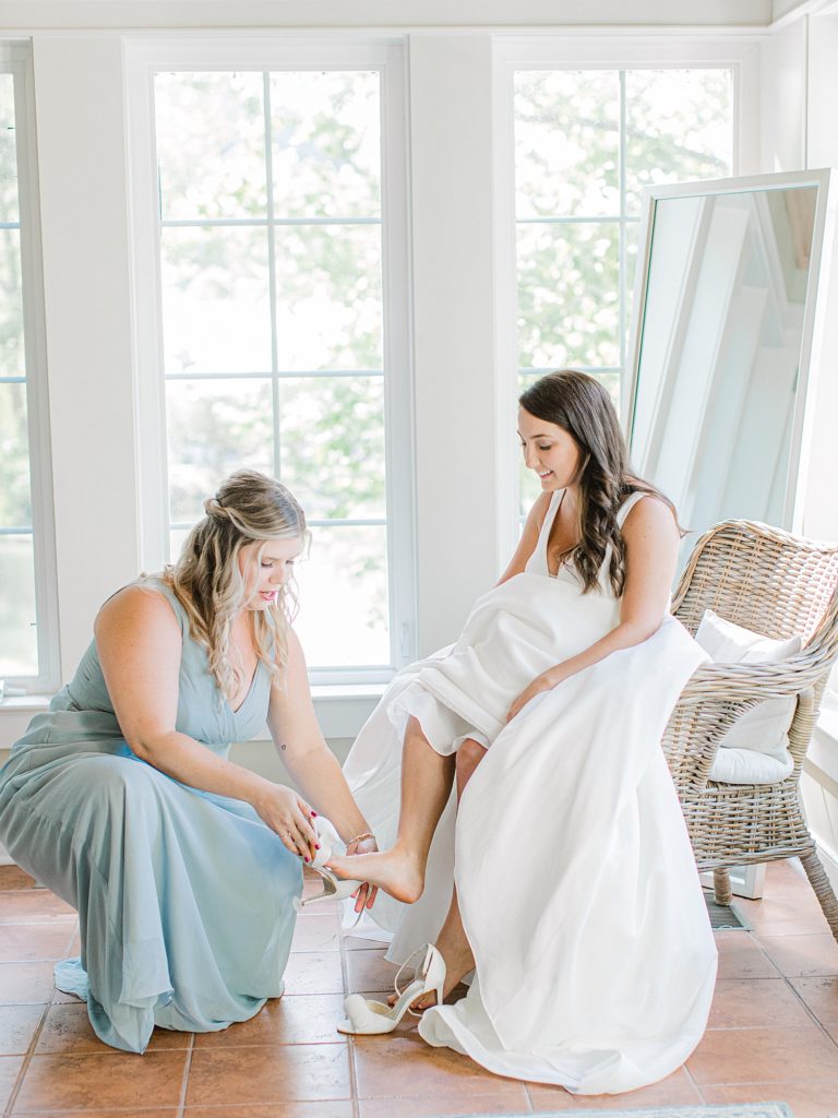 Maid of honor helping bride get ready.