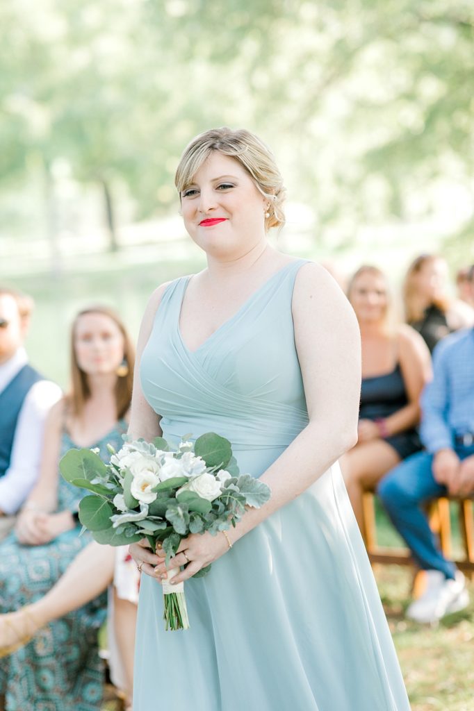 Bridesmaid walking down aisle for ceremony.