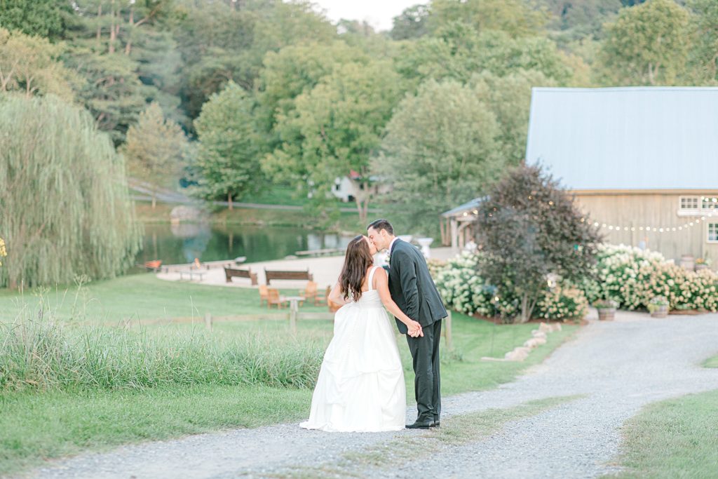 Bride and groom kissing in front of Big Spring Farm venue.
