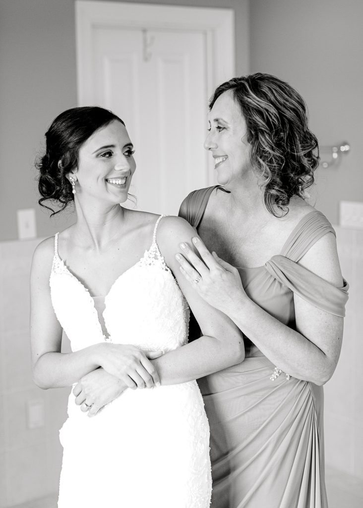 Mom and bride smiling at each other.
