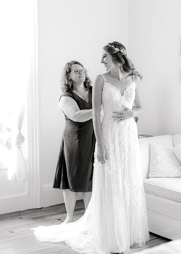 Mother helping bride into dress at Guildford Farm's bridal suite.