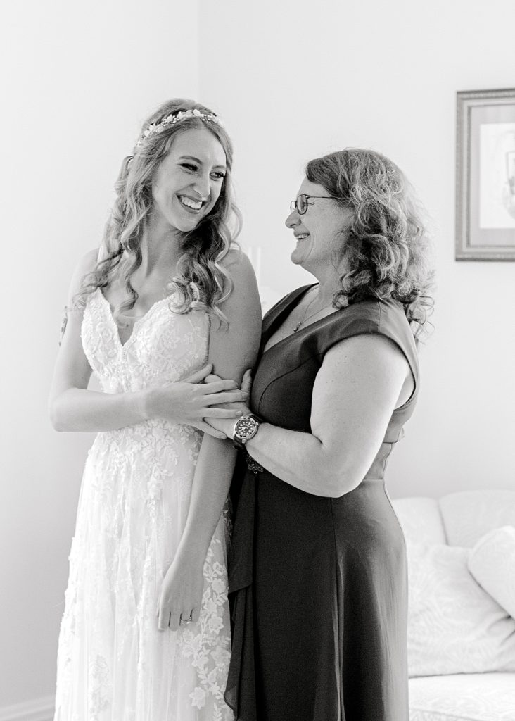 Mother helping bride into dress at Guildford Farm's bridal suite.