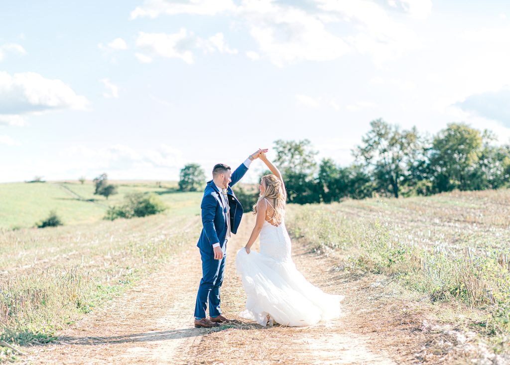 Bride and groom twirling in a field at Cross Keys Barn.