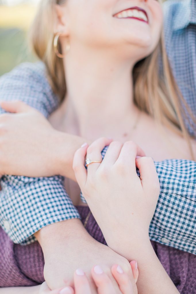 Close up photo of couple holding hands for engagement portraits at Big Spring Farm.