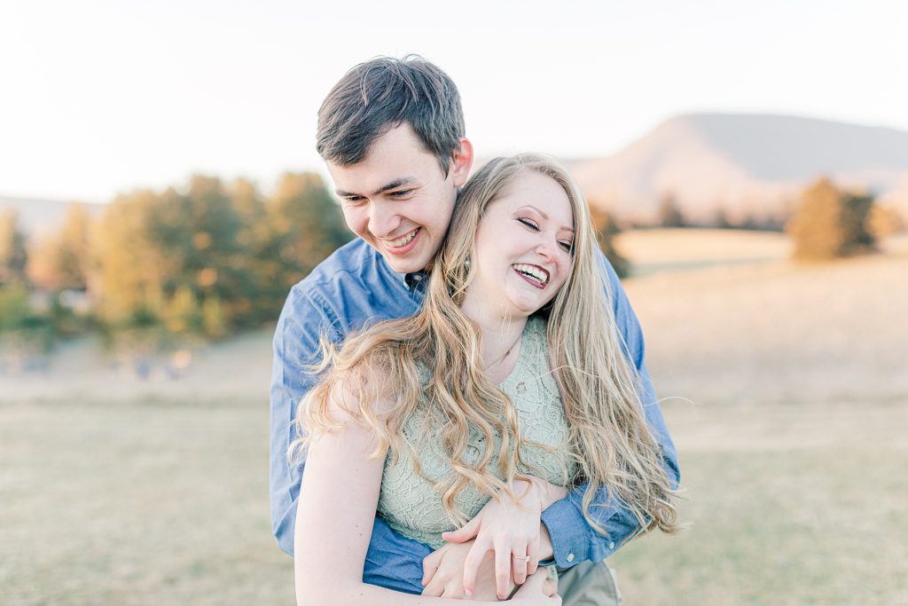 Couple laughing at camera during engagement session at Big Spring Farm.