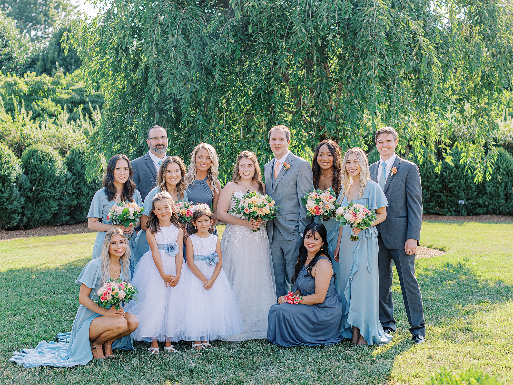 Groomswoman and bridesmaid, mixed gender bridal party gathered for photo.