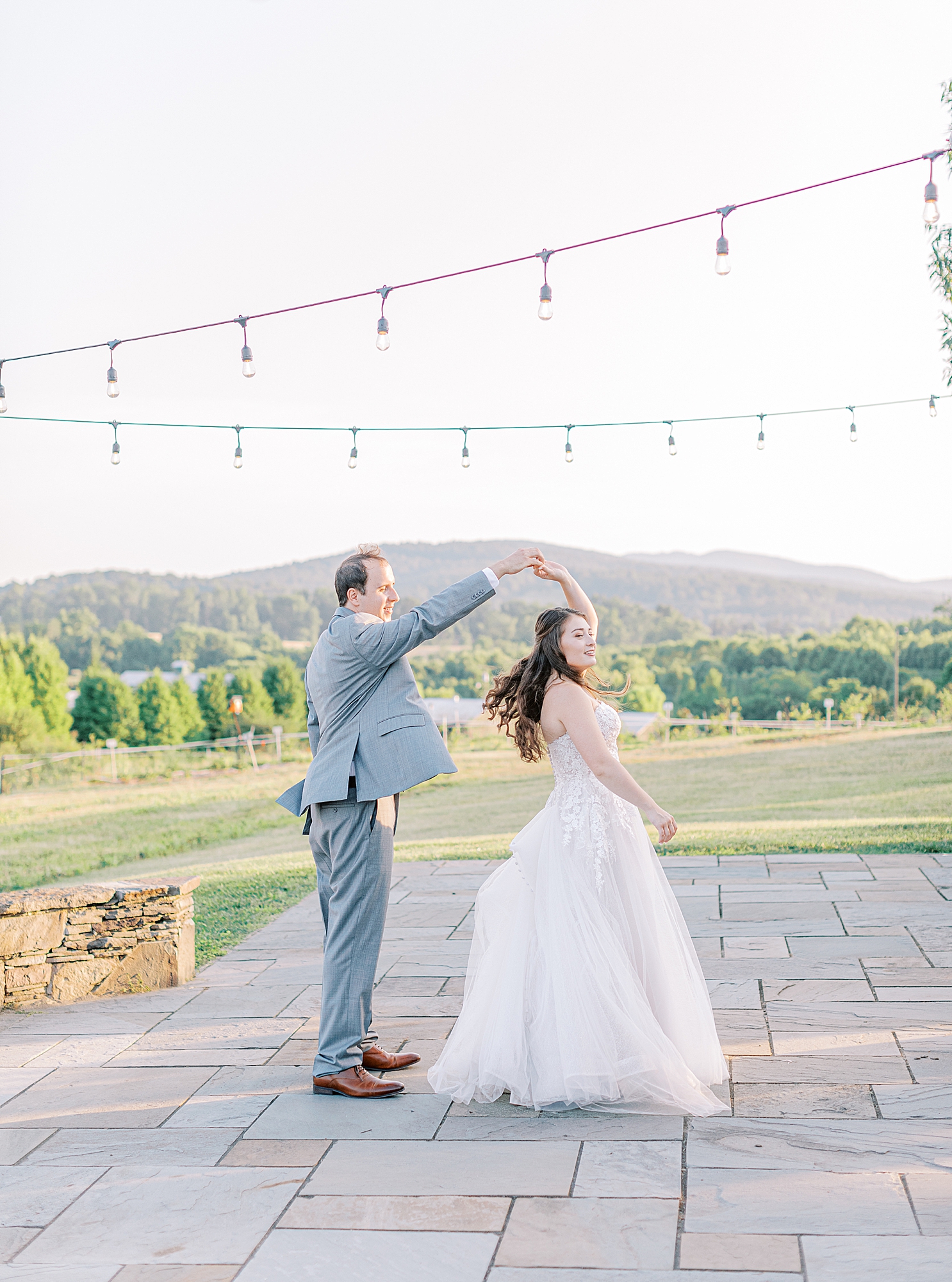 Groom twirling bride for portraits by Ashley Eagleson Photography.