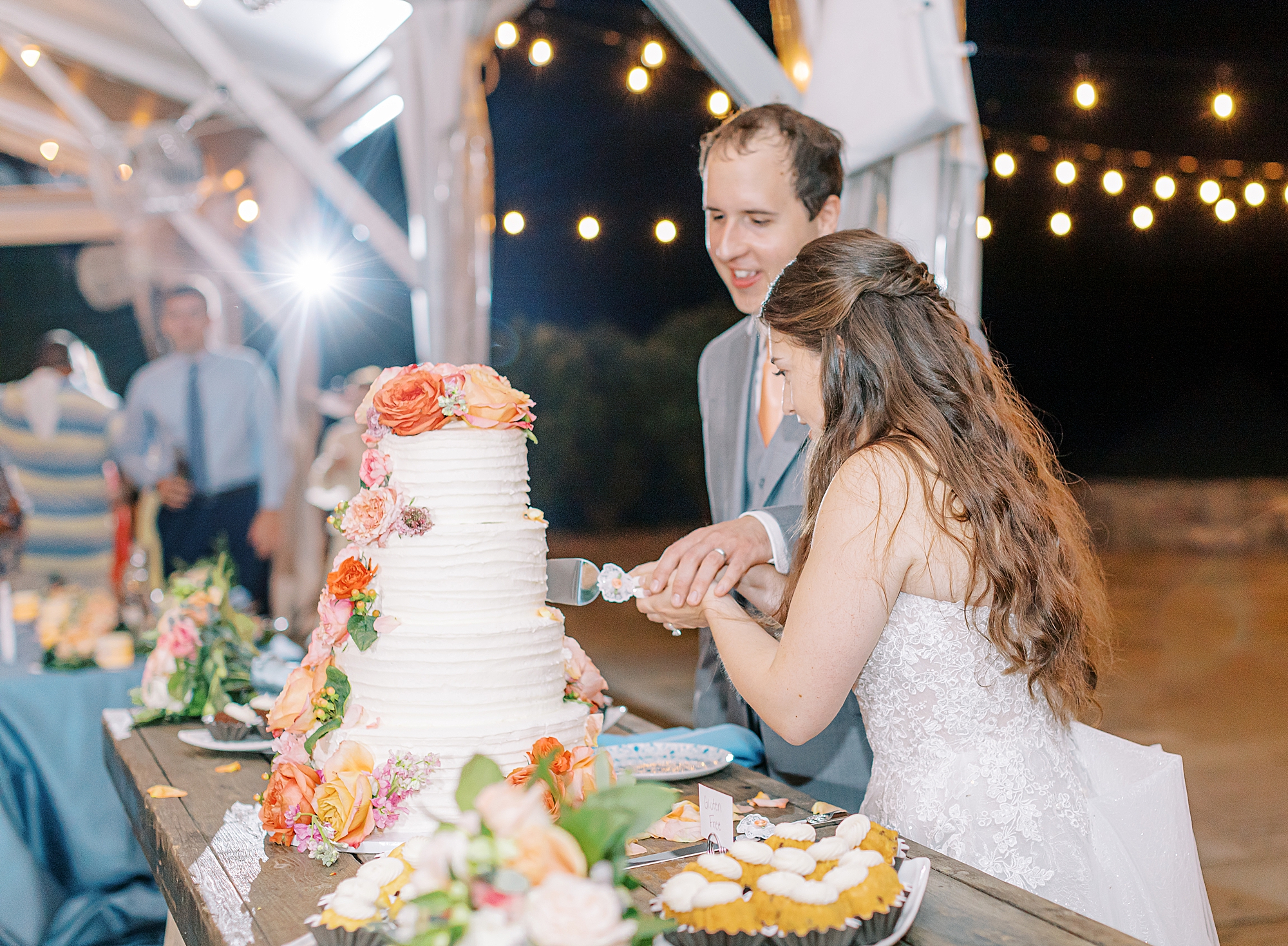 Bride and groom cutting white and coral cake at The Market at Grelen.