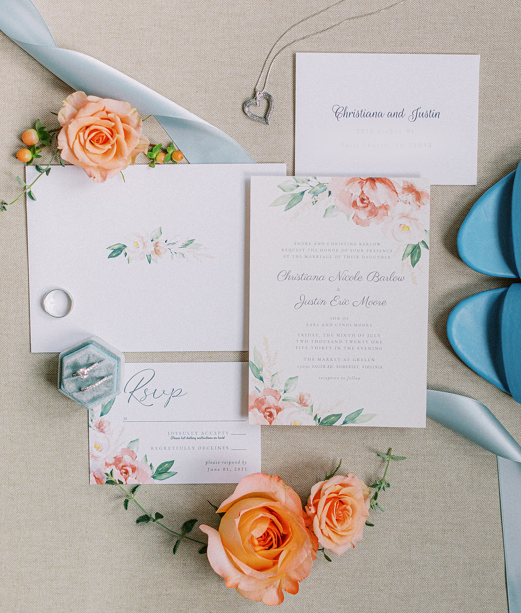 Invitation flatlay with coral and blue. Blue ring box.