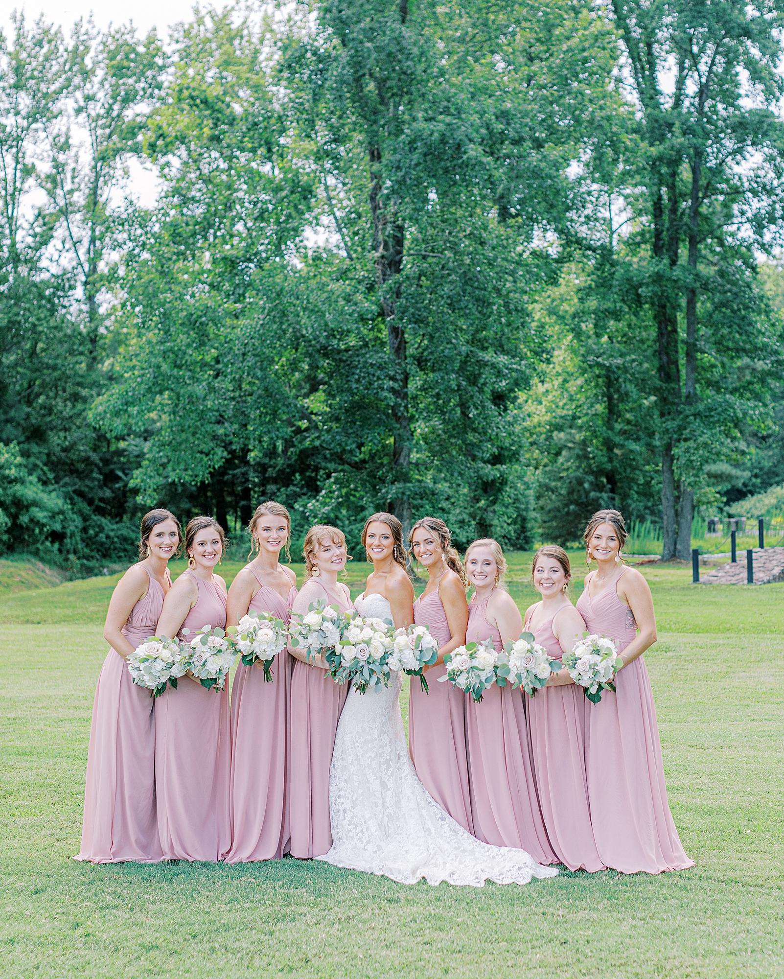 Bridesmaids holding bouquets smiling at the camera for Richmond wedding photographer at Alturia Farm.