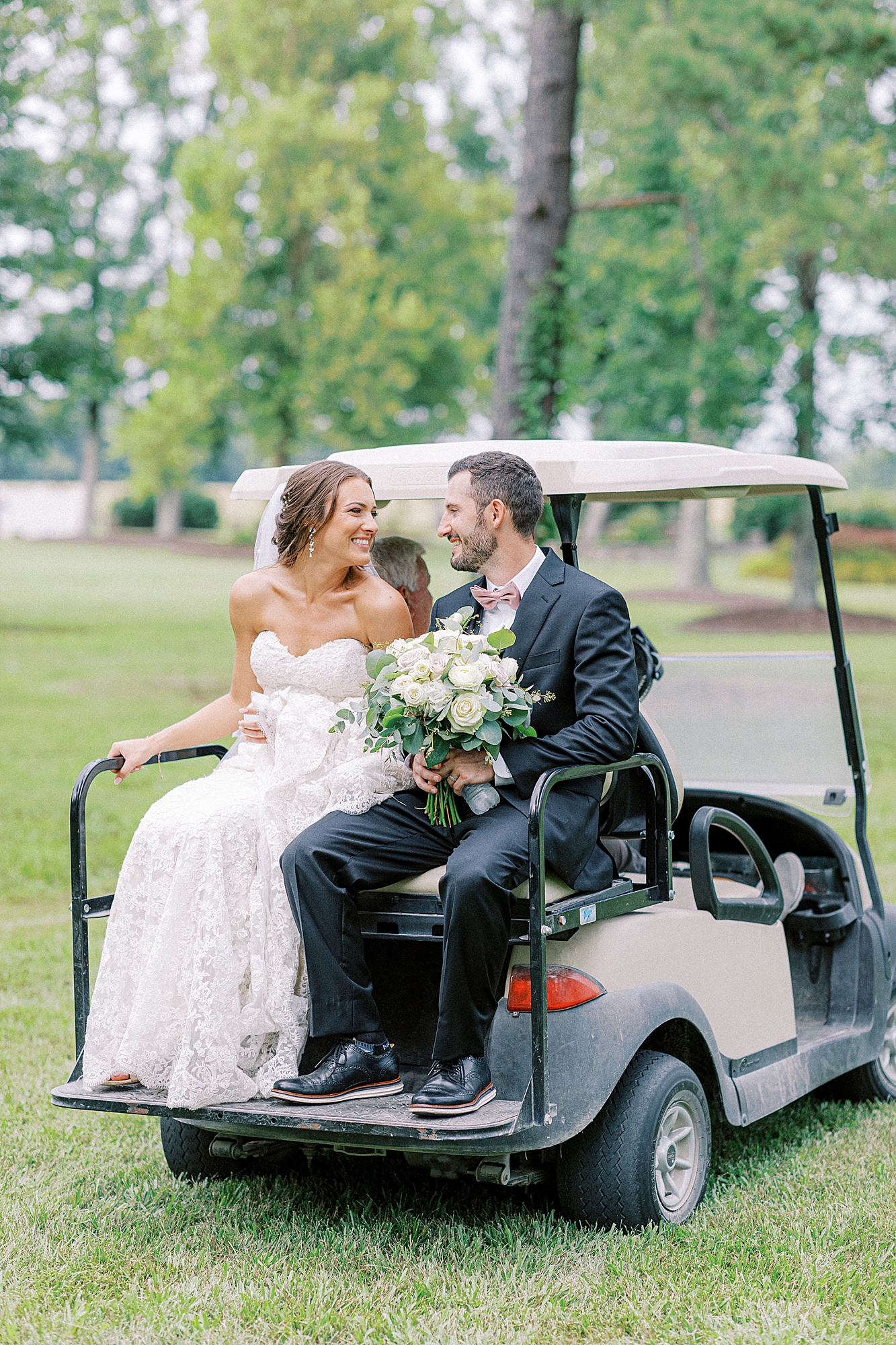 Bride and groom on golf cart heading towards their cocktail hour!