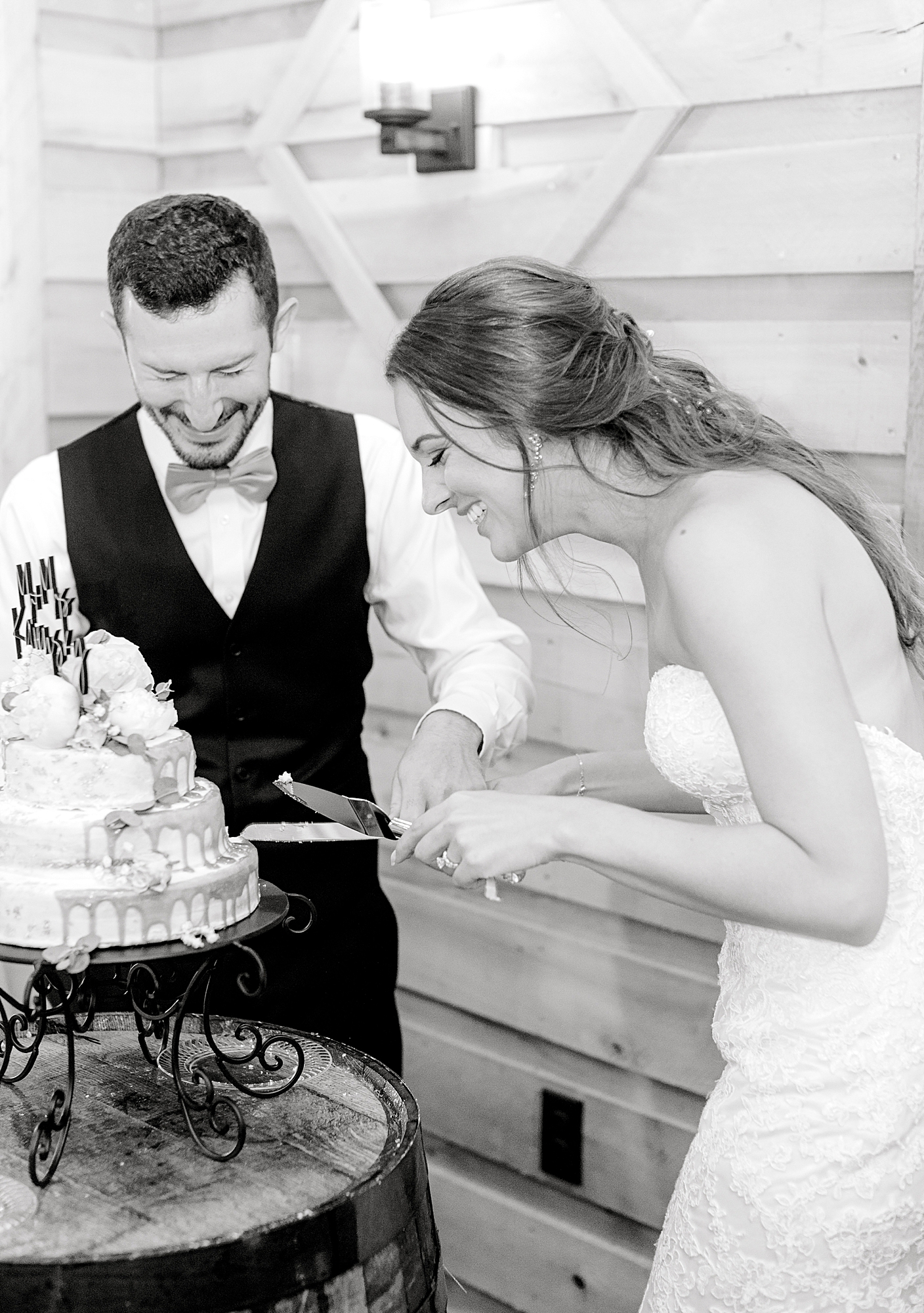Couple cutting the cake laughing at wedding reception during wedding in Richmond.