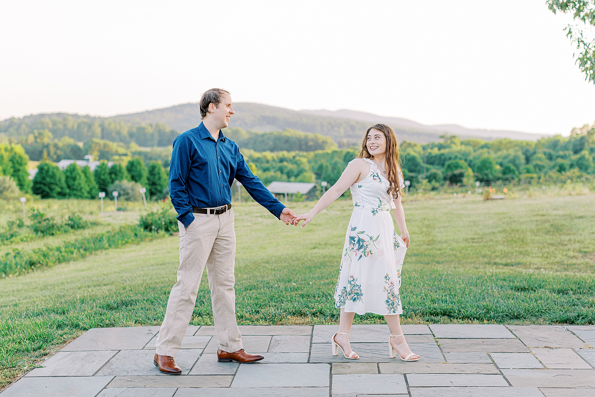 Couple walking across the orchard at The Market at Grelen during engagement session taken by Ashley Eagleson Photography.