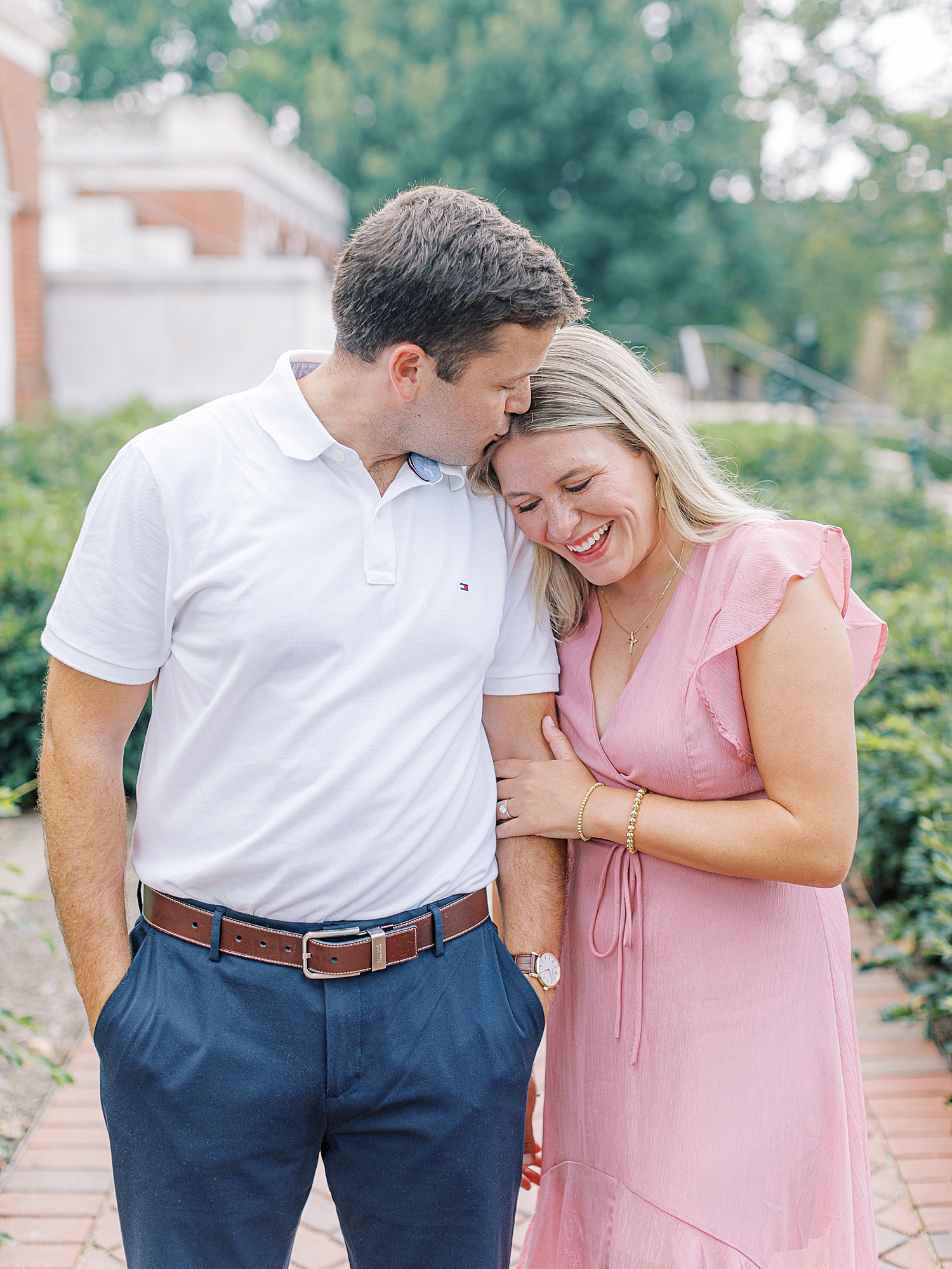 Man kissing fiancée’s forehead along the grounds at University of Virginia during engagement session. Photo taken by Charlottesville wedding photographer, Ashley Eagleson.