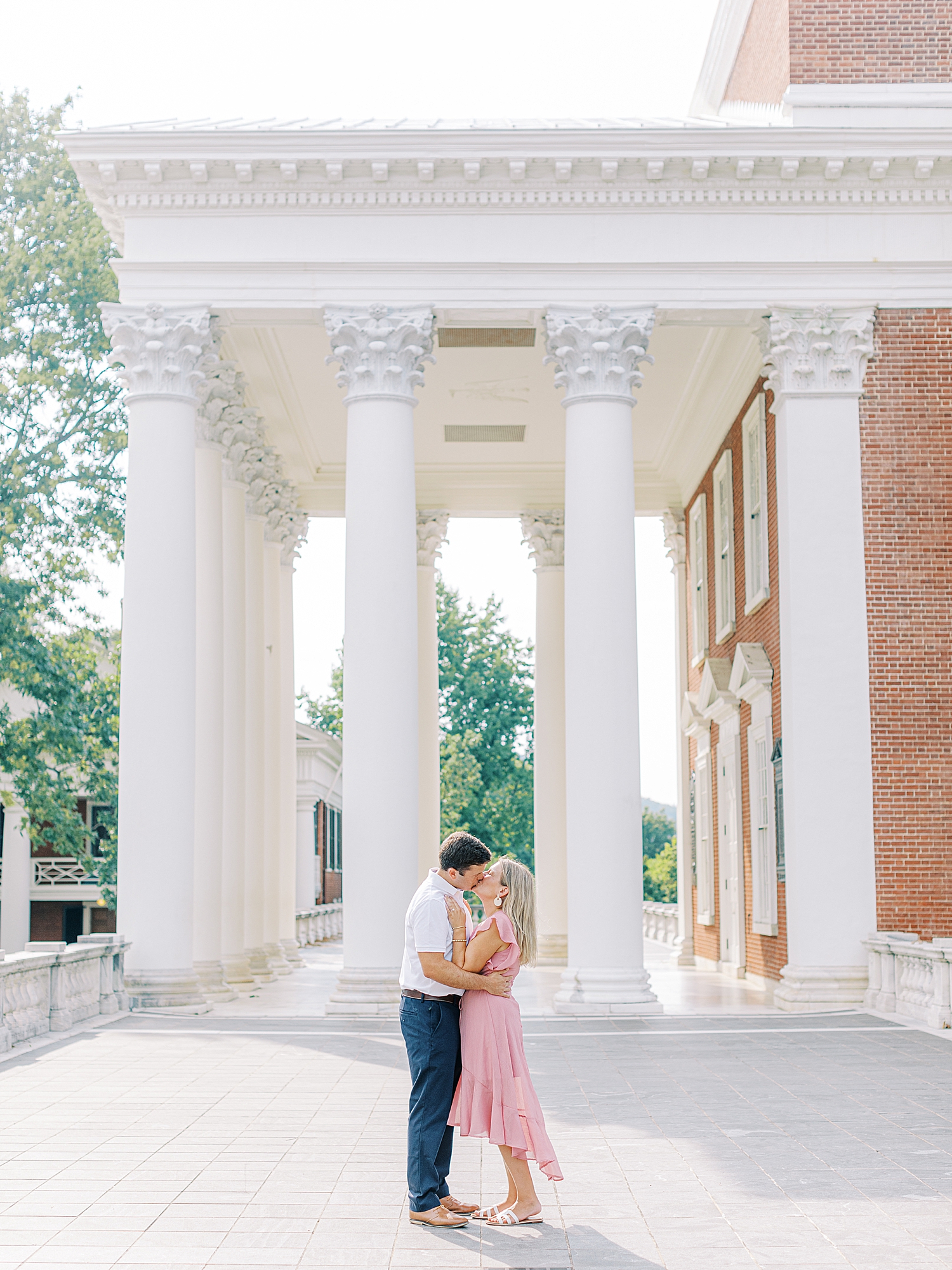 Couple kissing in front of the Rotunda at UVA during engagement session in the summer. 
