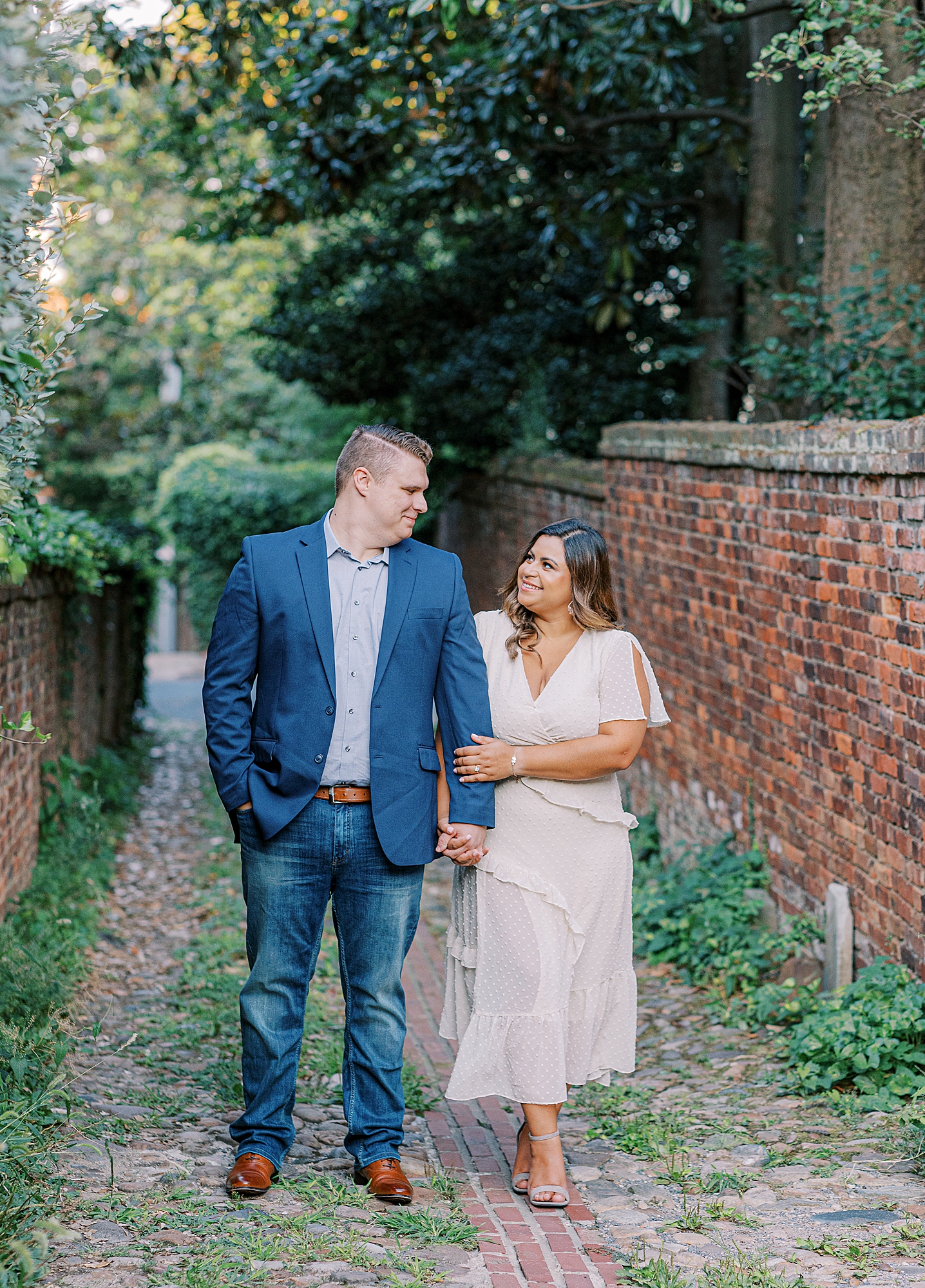Couple walking down alley in Old Town Alexandria during engagement session.