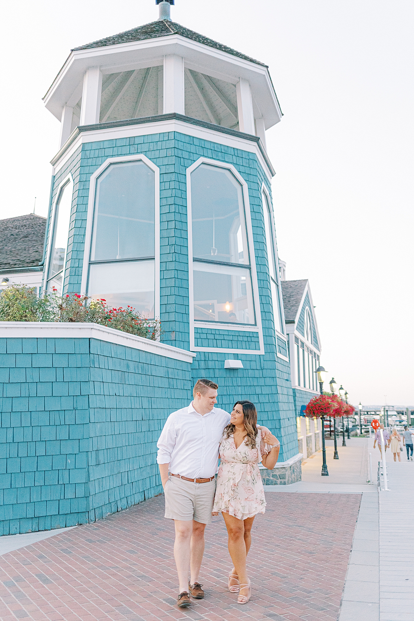 Couple walking in front of the Chart House for engagement session in Alexandria, Virginia.