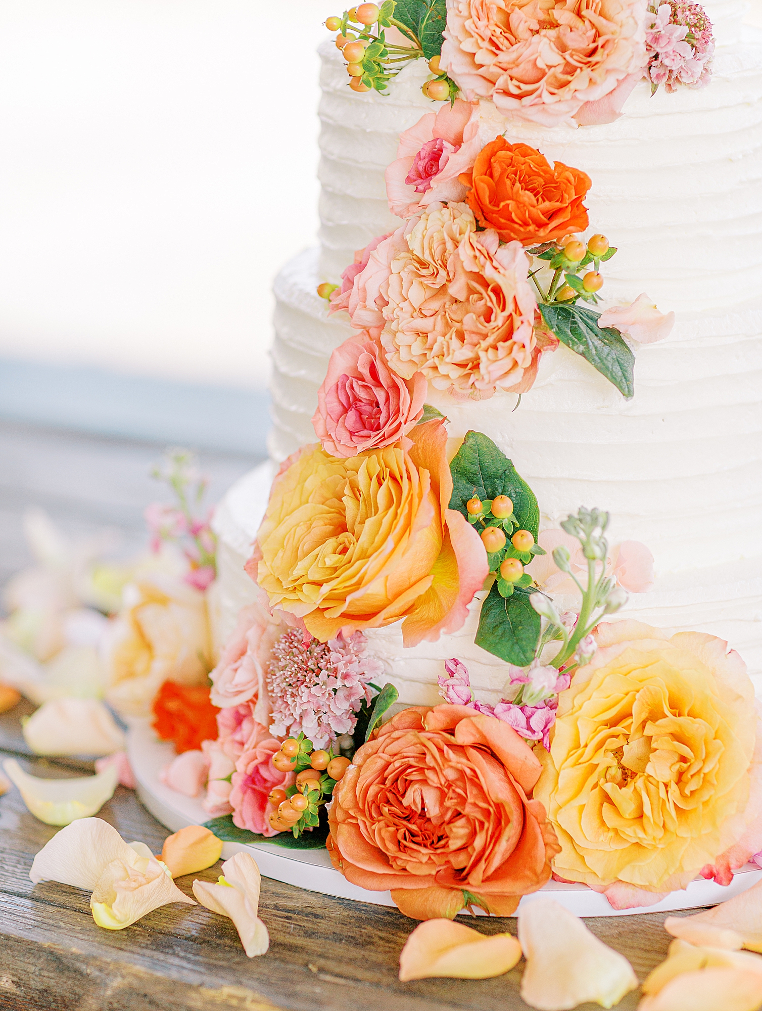 Coral florals on wedding cake.