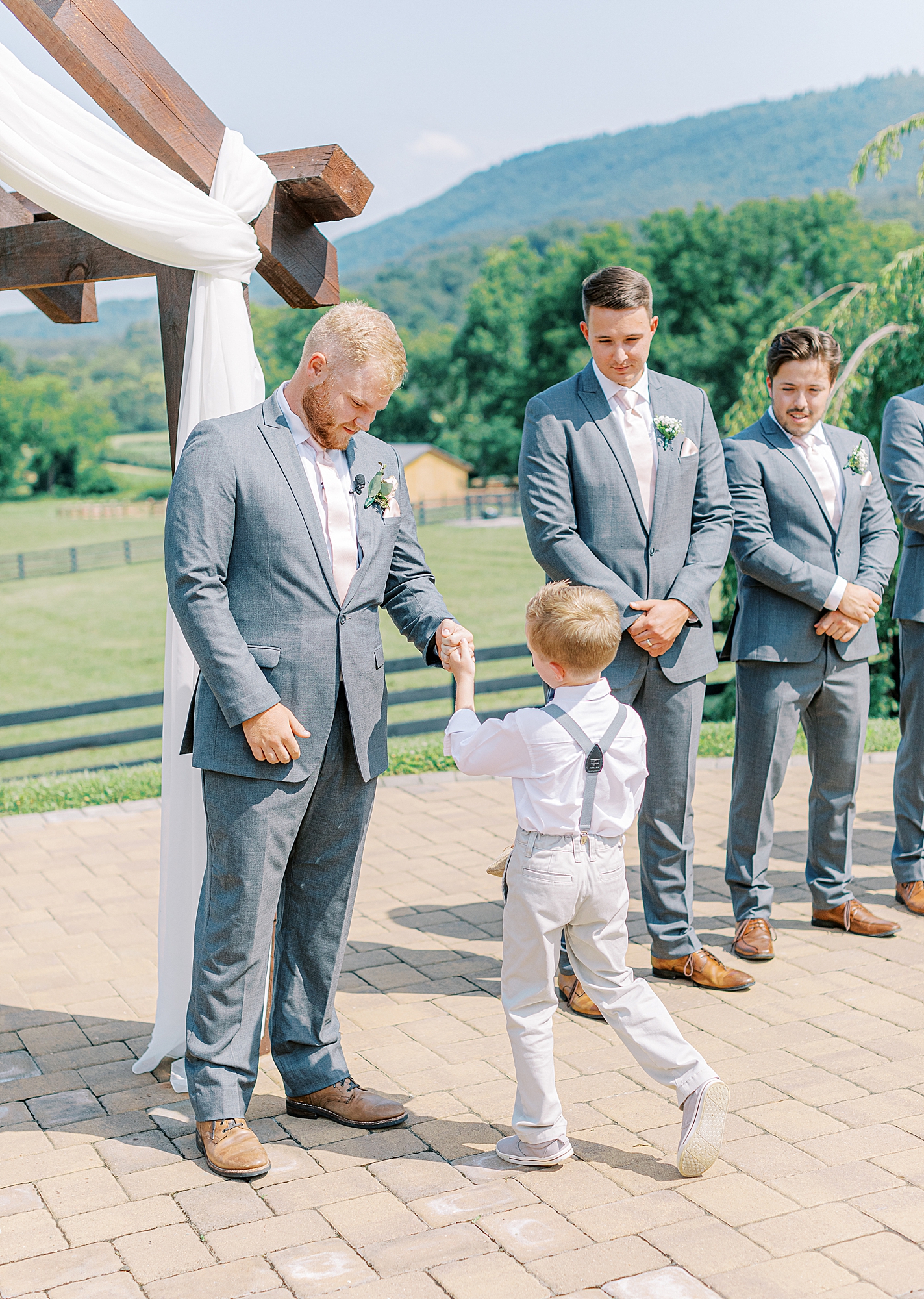 Groom fist bumping ring bearer down the aisle.