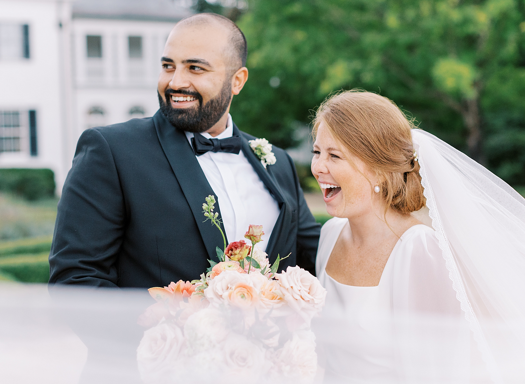 Couple laughing while veil flies at Keswick Vineyards taken by Richmond wedding photographer.