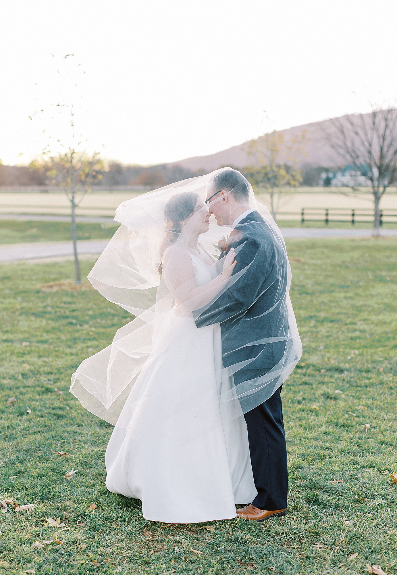 Bride and groom portraits wrapped in veil at King Family Vineyards.