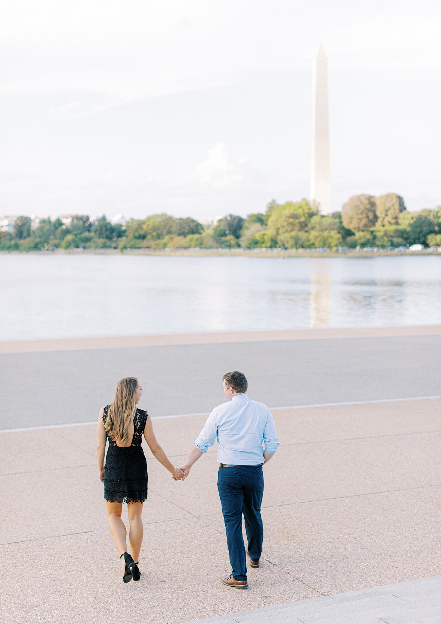 Couple walking by Jefferson Memorial for engagement photos in Washington DC.