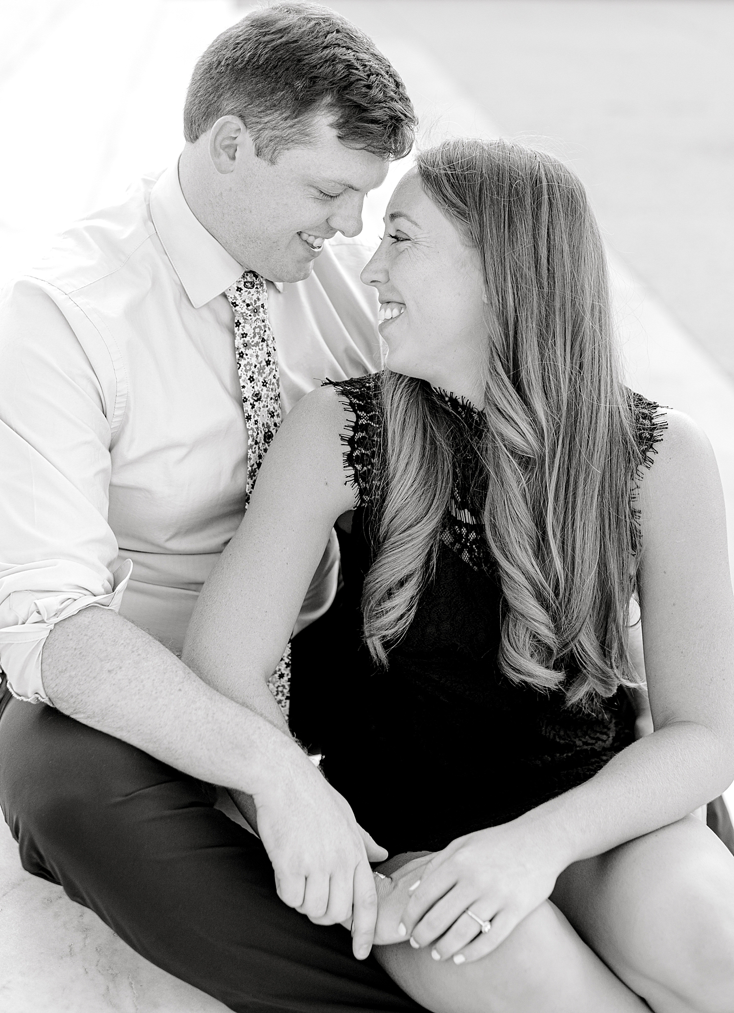 Black and white photo of couple smiling at each other.