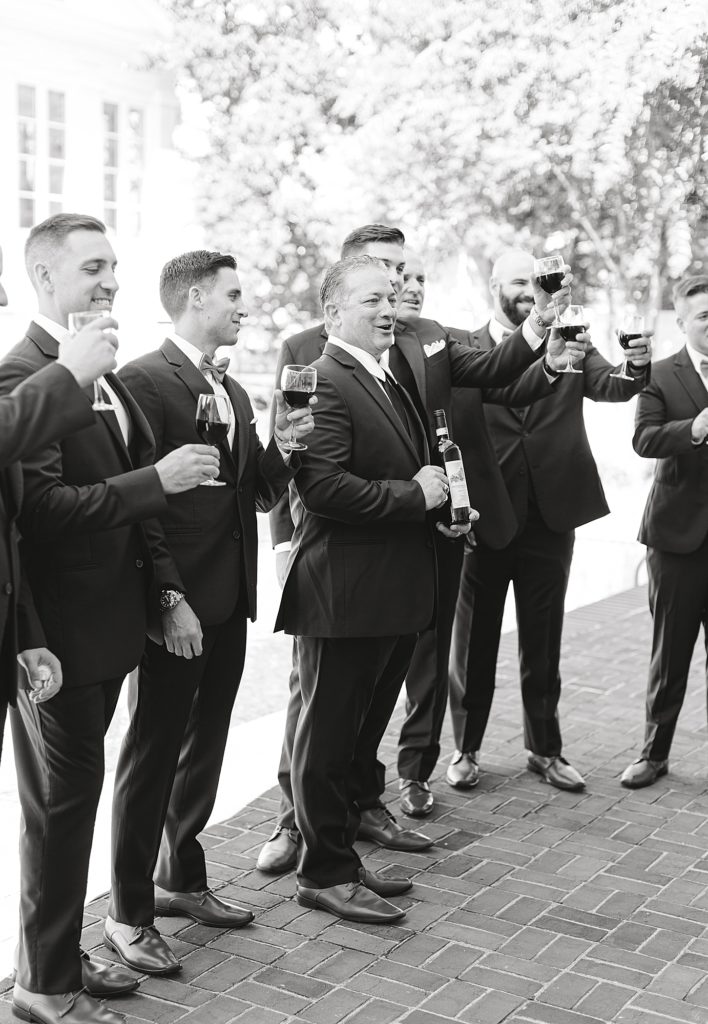 Groom with dad cheering with wine before ceremony.