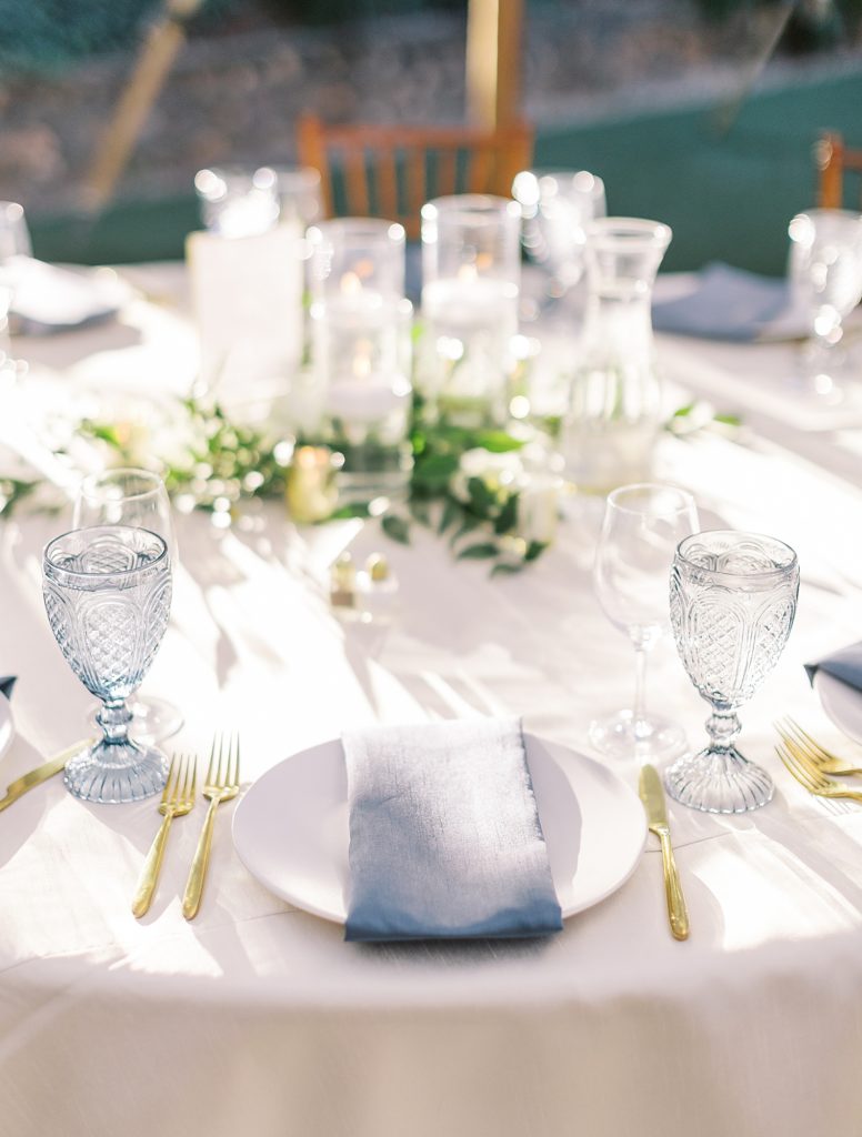 Reception table design with blue accents and gold utensils.