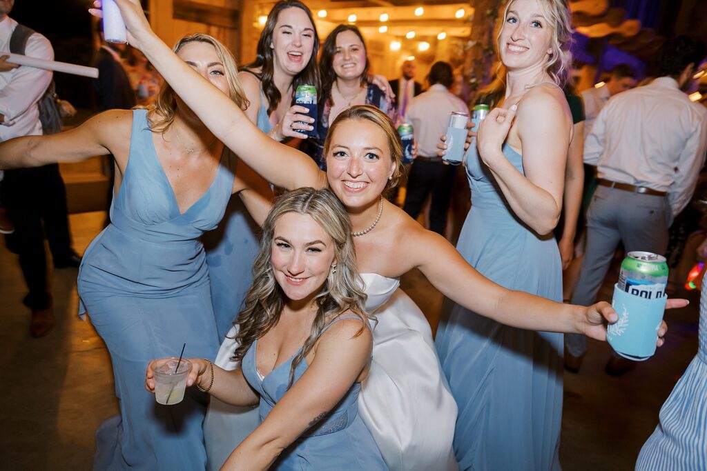 Bride and bridesmaids dancing at wedding reception.