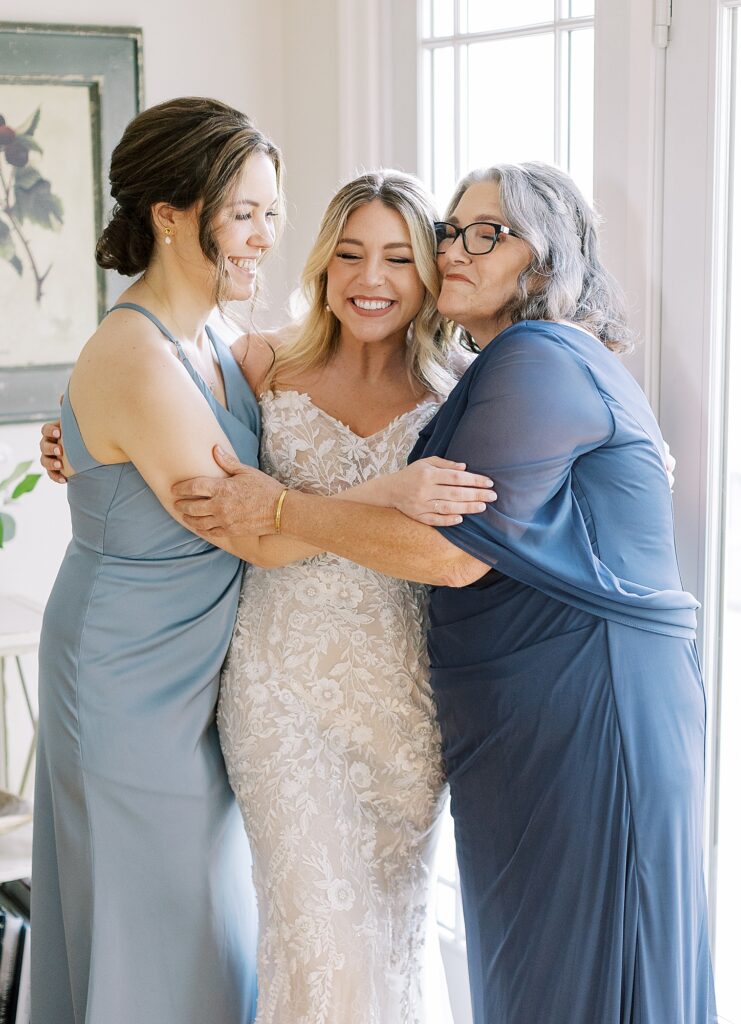 Bride hugging mother and sister during a heartfelt moment after getting ready.
