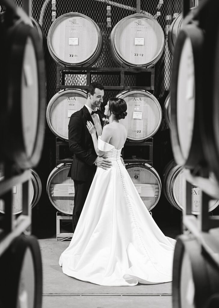Portrait of newlyweds in wine cellar.