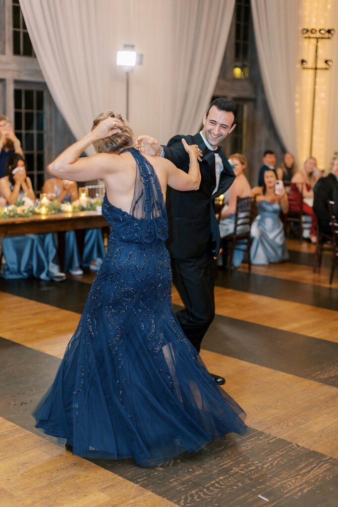 Groom twirling mother during dance.