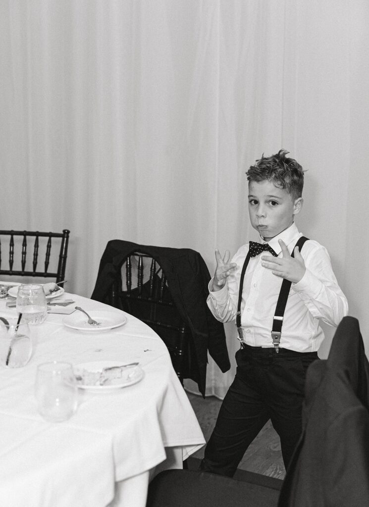 Kid at wedding reception eating cake.