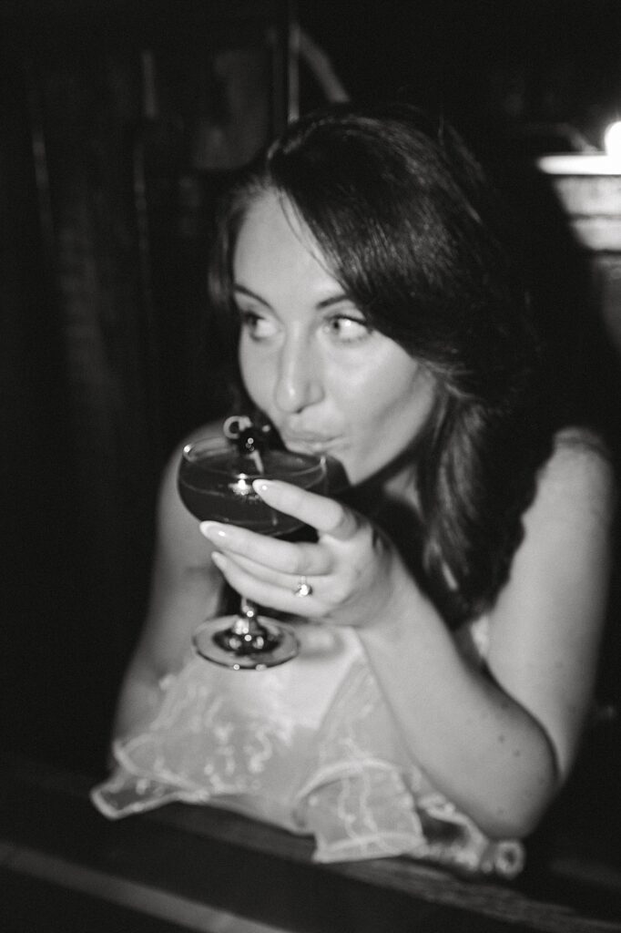 Black and white film inspired photo with girl sipping cocktail.