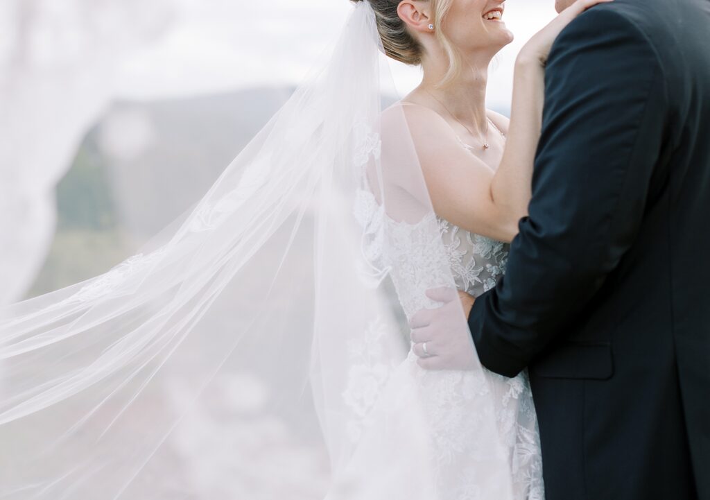 Bride wearing long veil with lace detail.